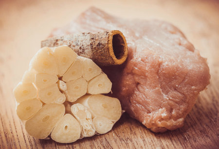 Raw beef with garlic and cinnamon on wooden surfaceの写真素材