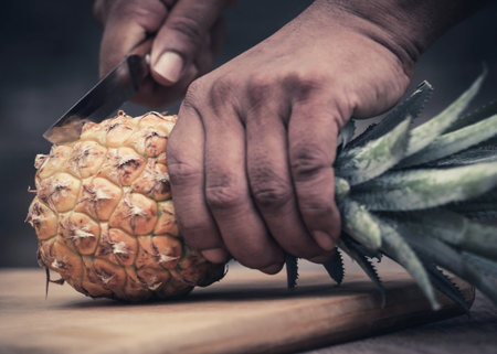 Cutting pineapple with a knifeの写真素材