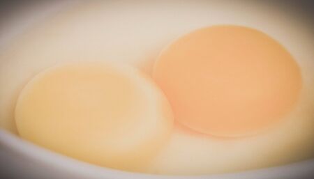 Closeup of two yolks in a bowlの写真素材
