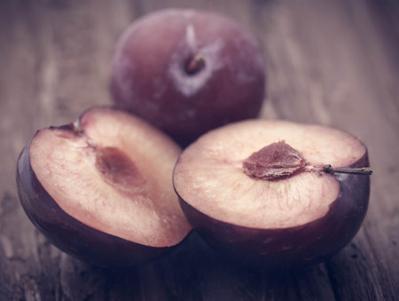 Fresh plums on textured surfaceの写真素材