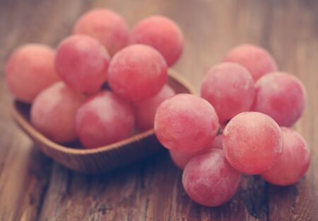 Organic red grapes in textured natural surfaceの写真素材
