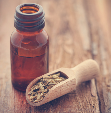 Fennel seeds with essential oil in a bottle on natural surfaceの写真素材