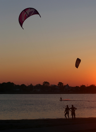 Learning kite surfing while the sun getting setの写真素材