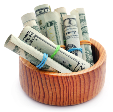 Rolled US Dollar in a wooden bowl over white backgroundの写真素材