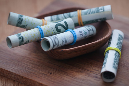 Rolled US Dollars in wooden bowl