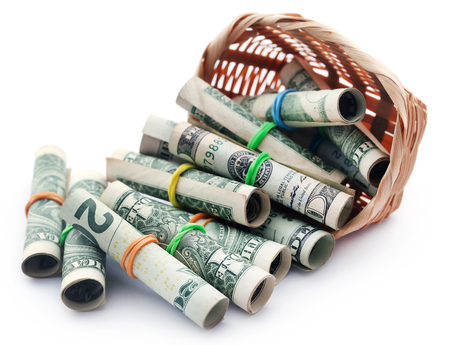 Rolled US Dollars falling out from a basketの写真素材