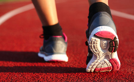 Woman running on athletic track at afternoon