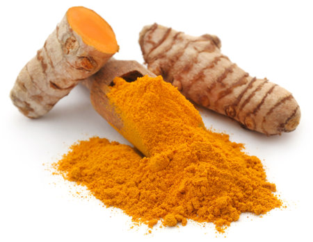 Raw turmeric with powder over white background