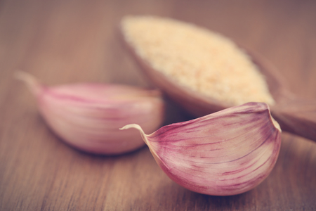 Garlic powder with garlic bulb on wooden surfaceの写真素材