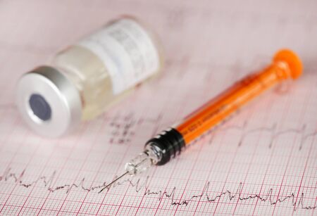 Syringe vial on printed electrocardiographの写真素材