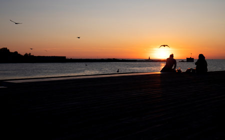 Silhouette of two women at Malmo harbor at late afternoonの写真素材