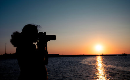 Silhouette of a photographer in action at Malmo harbor during late afternoonの写真素材