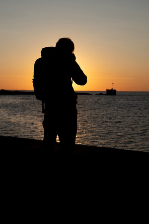 Silhouette of a photographer in action at Malmo harbor during late afternoonの写真素材