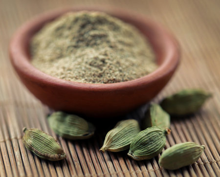 Cardamom with ground powder in bowlの写真素材