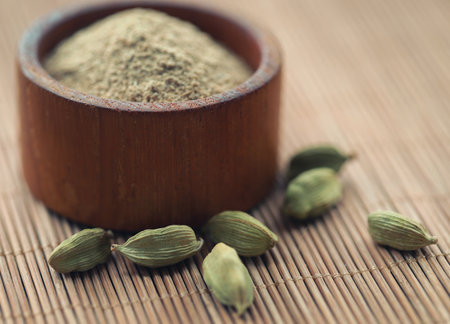Cardamom with ground powder in bowlの写真素材