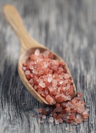 Himalayan pink salt in a wooden scoopの写真素材