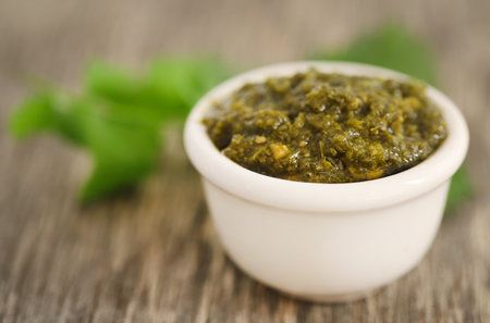 Mint pesto with fresh leaves on wooden surface closeupの写真素材