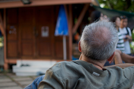 BANGKOK, THAILAND - 11th DECEMBER 2018 : Rear picture of a man sitting on a bench while he is...