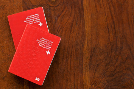 Top view of two Swiss Passports on a wooden table