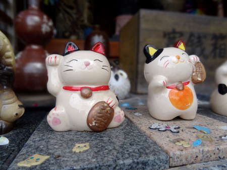 Close up picture of two Maneki-Neko ceramic figures at the shrine of the Sumoto Castle on Awaji Island, Japanのeditorial素材