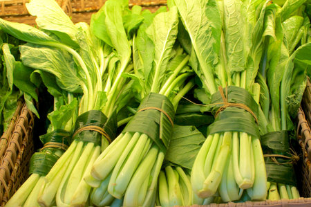 Close up picture of some spinach (vegetable) wrapped and bundled in banana leaves. This is an...
