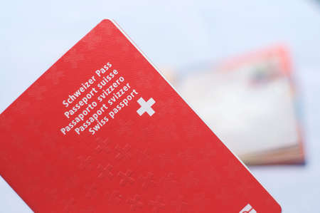 Close up view of one Swiss passports with a blurred open swiss passport on the backgroundの写真素材