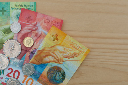 Close up picture of Swiss Banknotes and coins on a wooden table