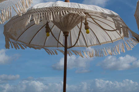Picture of a beautiful white Balinese sun umbrella, decorated with yellow bulb lights and located at the famous Echo Beach in Canggu, Bali - Indonesiaの写真素材