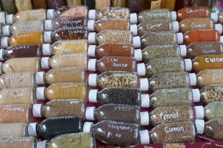 Many glass bottled filled with spices lined at the Samadi Organic food Market in Canggu, Bali -...