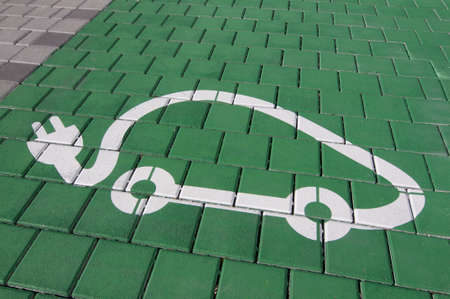 Close up picture of a electric vehicle charger station symbol on a green background, captured in Lugano (Ticino) - Switzerlandの写真素材