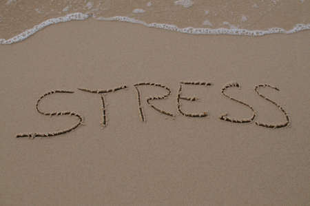 Stress text inscription drawn in the sand with coming waterの写真素材