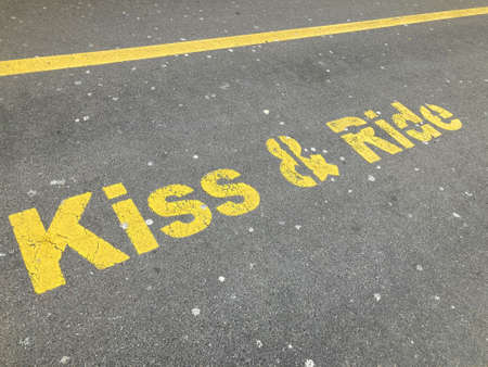 Yellow Kiss and Ride inscription painted on asphalt at the drop off parking station in Zug, Switzerlandの写真素材