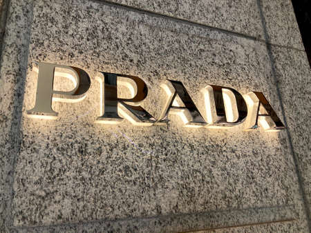 Lugano, Ticino, Switzerland - 10th March 2021 : Illuminated Prada sign hanging on the store wall in Lugano. Prada is a international italian luxury clothing companyのeditorial素材