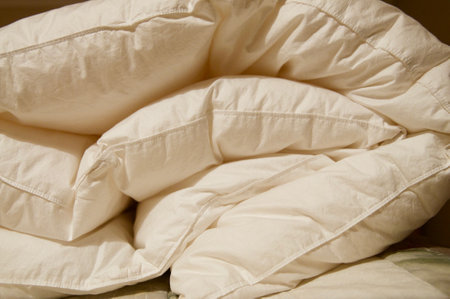 Soft folded white blanket close up on a bed at homeの写真素材
