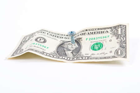 Dollar bill with screw through the middle of George Washinton's head.の写真素材