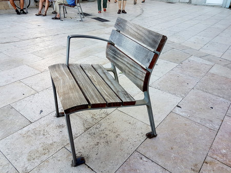 Close-up shot of a weathered street bench on the promenade in Sitges, Spain.