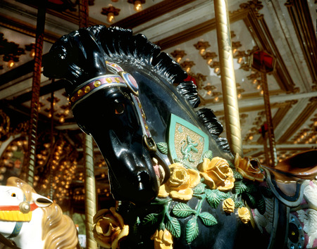 black carousel horse with yellow rosesの写真素材