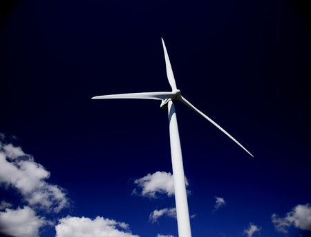 horizontal image of a Hawt wind turbine against a slate blue sky horizontal image of a Hawt wind turbine against a slate blue sky