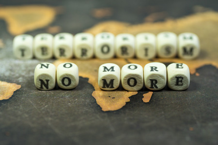 Wooden blocks with the text, NO MORE TERRORISM, on the background of world mapの写真素材