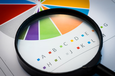 Business Analysis Image-magnifying glass on graphs and spreadsheetの写真素材