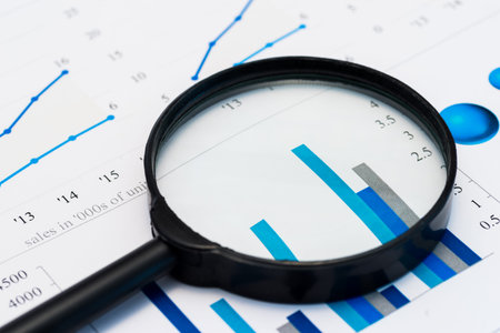 Business Analysis Image-magnifying glass on graphs and spreadsheetの写真素材