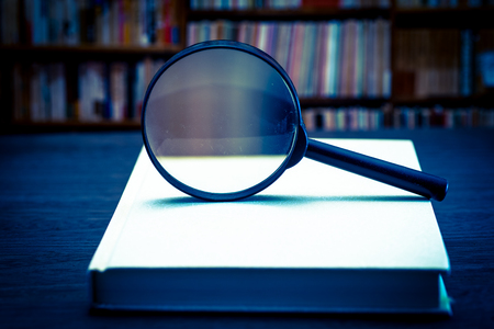 Magnifying glass on books at tableの写真素材