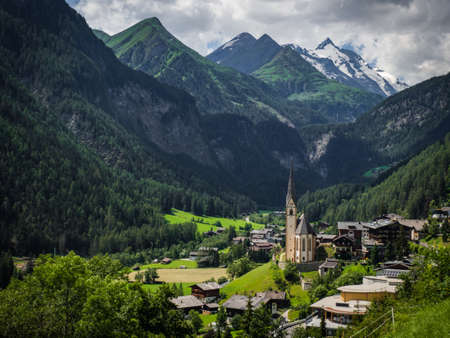Charming scenic view to the highest mountain in Austria, Grossglockner with his glaciers cover with snow and nice city Heiligenblut down in the valley in Hohe Tauern national park, Austria, Europe.の写真素材