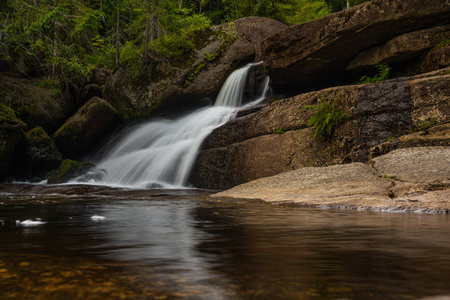 Amazing waterfall hidden deep in Jizera mountains, Czech Republic. Calm and peaceful place with water flowing in cascade river.の写真素材
