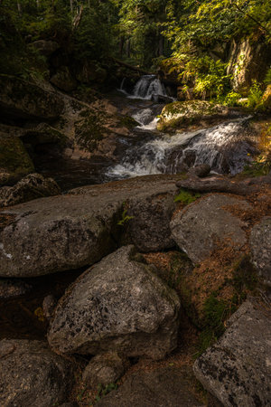 Amazing waterfall hidden deep in Jizera mountains, Czech Republic. Calm and peaceful place with water flowing in cascade river.の写真素材