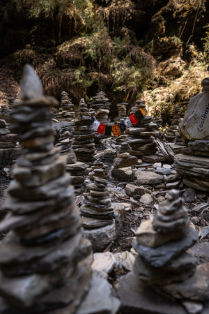 Prayer flags hung between towers of stones in a dry riverbed.の写真素材