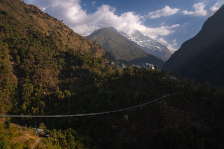 Long suspension bridge over the river in the jungle at the foot of the Himalaya mountains in Nepal...