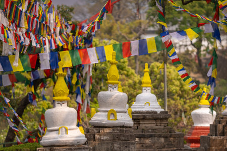 Colorful prayer flags and traditional Buddhist stupas in Swayambhunath area, known as monkey temple,...