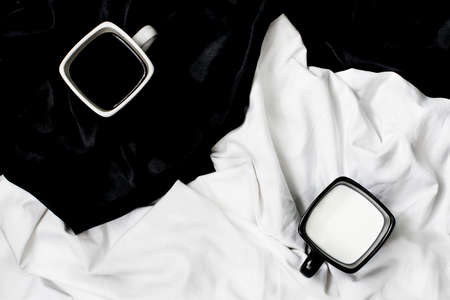 Cup of coffee and cup of milk on black and white background の写真素材