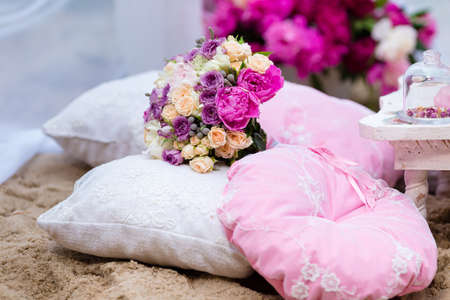 Beautiful, delicate bridal bouquet among decorations with pillow.の写真素材